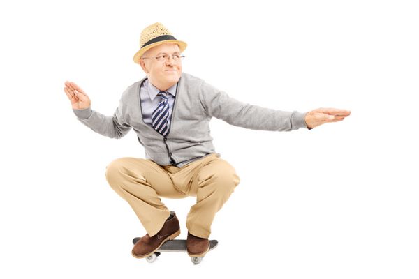 مرد سالخورده با کلاه سوار بر اسکیت برد جدا شده روی پس زمینه سفید