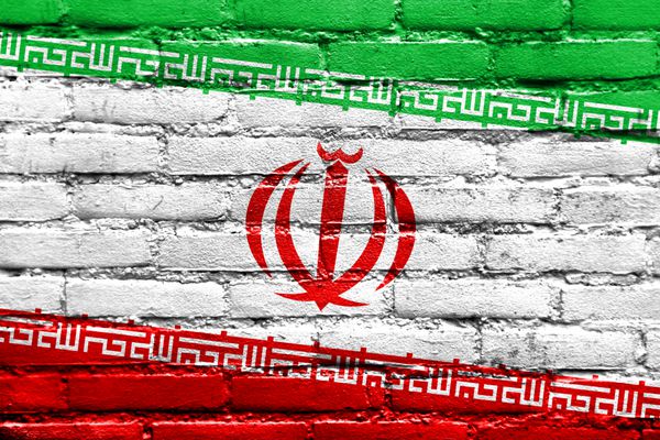 پرچم ایران بر روی دیوار آجری نقاشی شده است