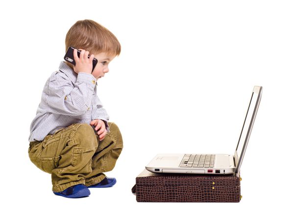 پسر جذاب با تلفن صحبت می کند و به لپ تاپ نگاه می کند