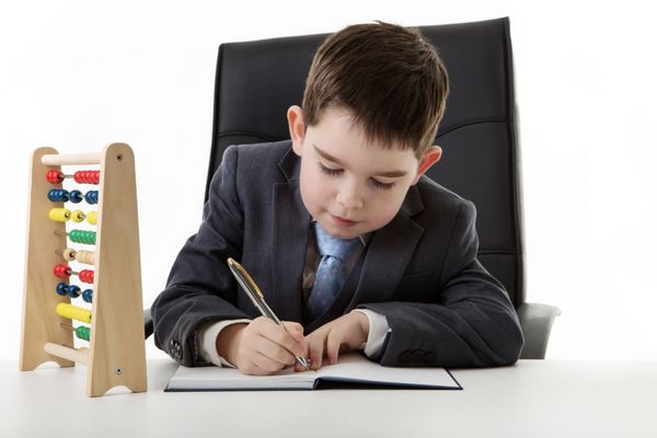 پسر جوانی که وانمود می کند در یک دفتر کار می کند و چرتکه روی میزش است