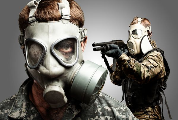 سربازان جوان با پوشیدن ماسک گاز روی پس زمینه خاکستری