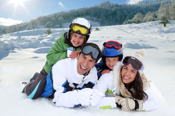 خانواده شادی که در برف دراز کشیده اند
