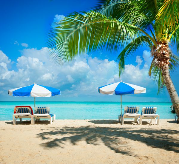 مفهوم تعطیلات و گردشگری تخت های آفتابگیر در ساحل بهشت