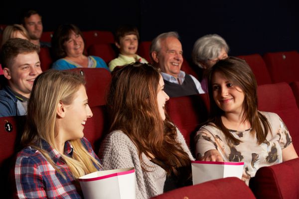 گروه دختران نوجوان در حال تماشای فیلم در سینما