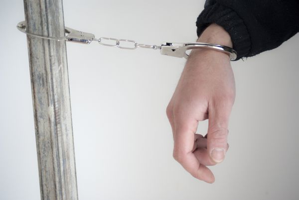 نزدیک مرد دستگیر شده با دستبند به یک دست