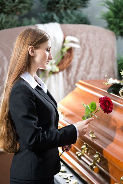 زن عزادار در تشییع جنازه با تابوت