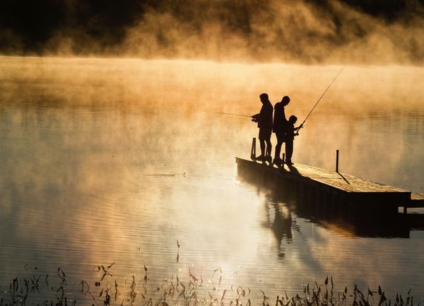 ماهیگیری صبح زود در پاییز در یک دریاچه