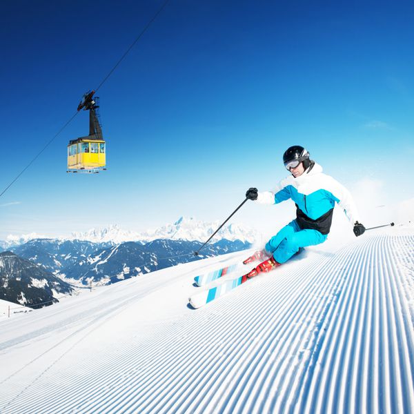 اسکی باز در کوه پیست آماده و روز آفتابی