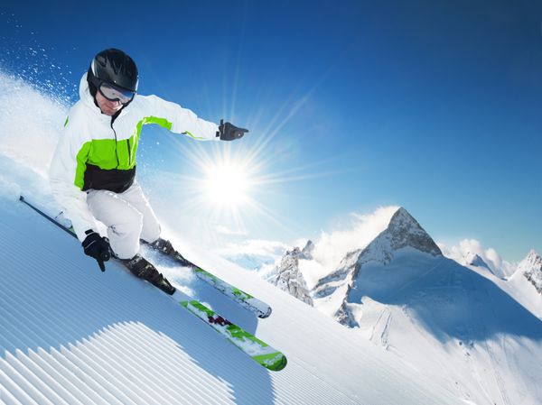اسکی باز در کوههای بلند در روز آفتابی