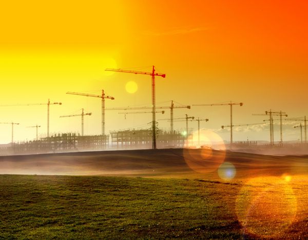 paisaje de atardecer gruas y edificios en construccion