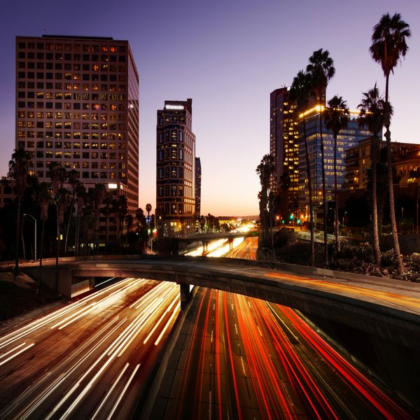 شهر لس آنجلس کالیفرنیا در غروب آفتاب با مسیرهای نورانی