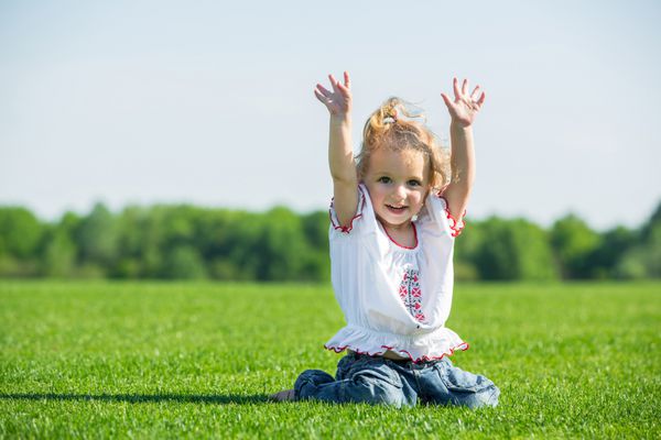 دختر کوچولوی شاد روی یک چمن