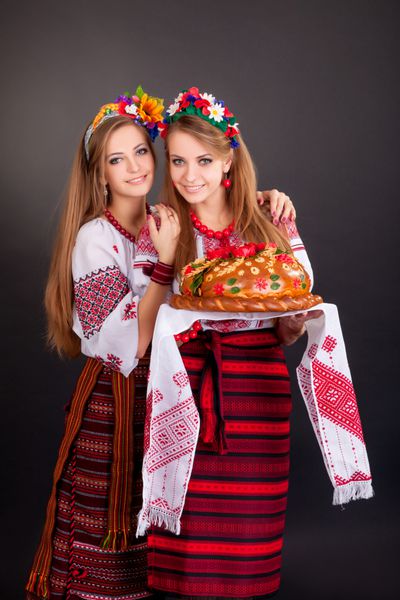 زنان جوان با لباس اوکراینی با حلقه گل و نان گرد