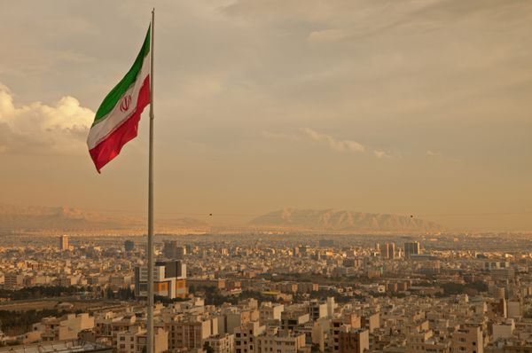 پرچم ایران در وزش باد بر فراز آسمان تهران
