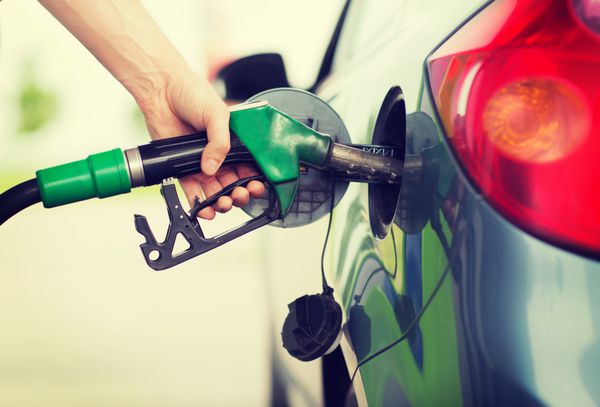 مردی که سوخت بنزین را در ماشین پمپ بنزین پمپ می کند