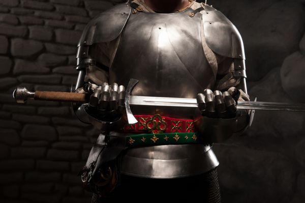 پرتره نزدیک شوالیه قرون وسطی در زره پوش که شمشیری در دست دارد