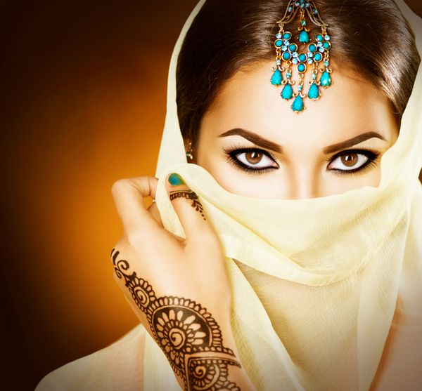 پرتره زیبای دختر عربی زن جوان هندو با مهندی از حنای سیاه روی دستانش پرتره مدل هندی زیبایی با آرایش روشن که او را پشت حجاب پنهان کرده است