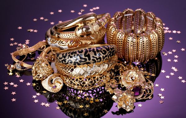 جواهرات طلایی زیبا در زمینه بنفش