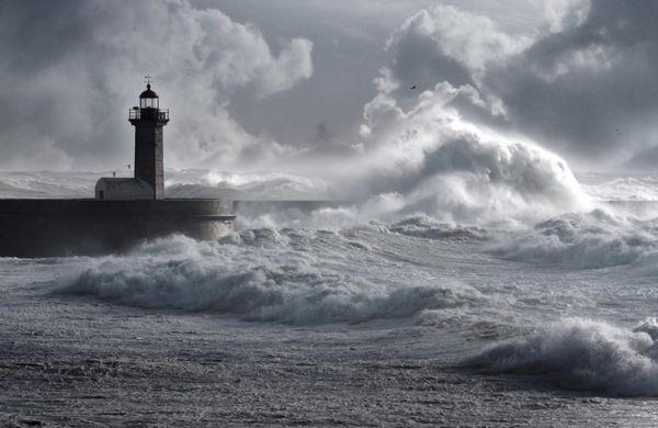 امواج طوفان بر فراز فانوس دریایی پرتغال - آسمان افزایش یافته است