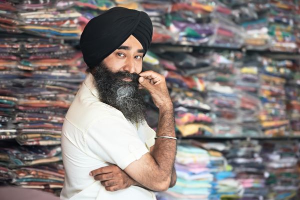 پرتره مرد سیک هندی فروشنده عمامه با ریش پرپشت در مغازه