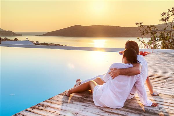 زن و شوهر در آغوش در حال تماشای طلوع خورشید با هم در یونان