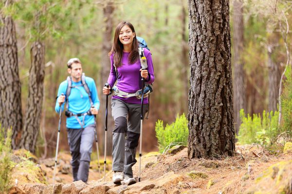 کوهنوردان در جنگل زوج پیاده روی در جنگل پاییزی زن آسیایی کوهنورد در مقابل لبخند شاد po از آگوامانسا اوروتاوا تنریف جزایر قناری اسپانیا