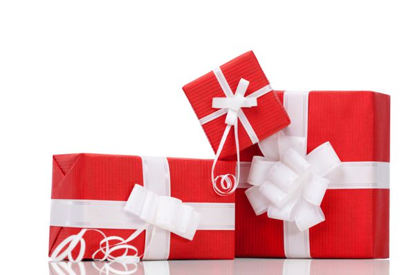 جعبه هایی با هدایای کریسمس پیچیده شده در کاغذ قرمز جدا شده روی سفید