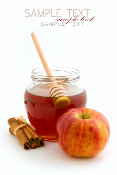 عسل در ظرف شیشه ای و سیب با چوب دارچین در زمینه سفید
