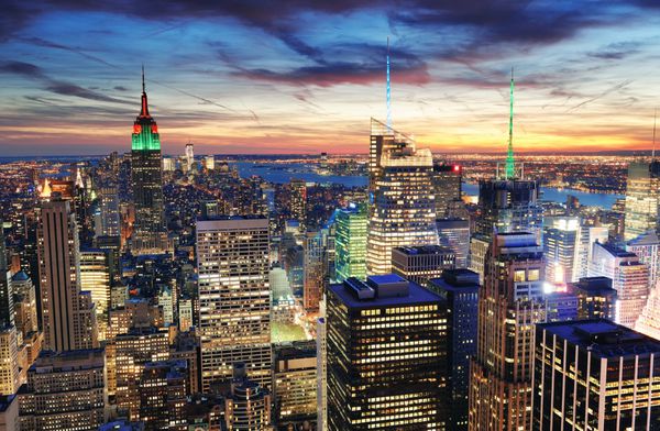 خط افق شهر نیویورک با آسمان خراش های شهری در غروب آفتاب