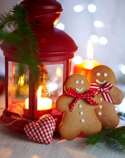 تزیینات کریسمس با مرد شیرینی زنجفیلی چراغ با شمع و گلدان های کریسمس