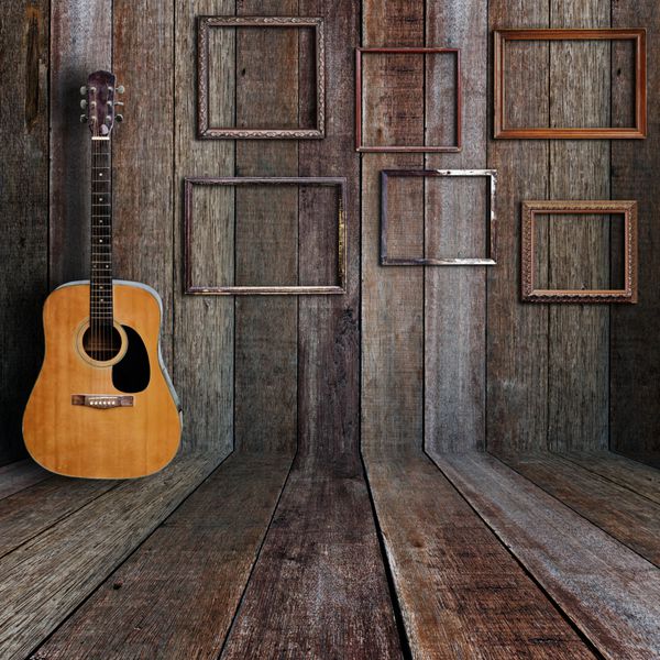 گیتار و قاب عکس در اتاق چوبی قدیمی
