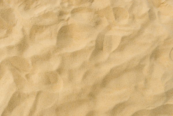 نمای نزدیک از الگوی شنی ساحل در تابستان