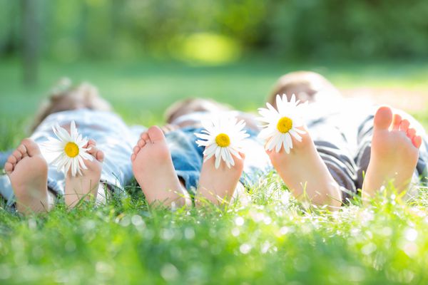 گروهی از کودکان شاد با گل هایی که در فضای باز در پارک بهار خوابیده اند