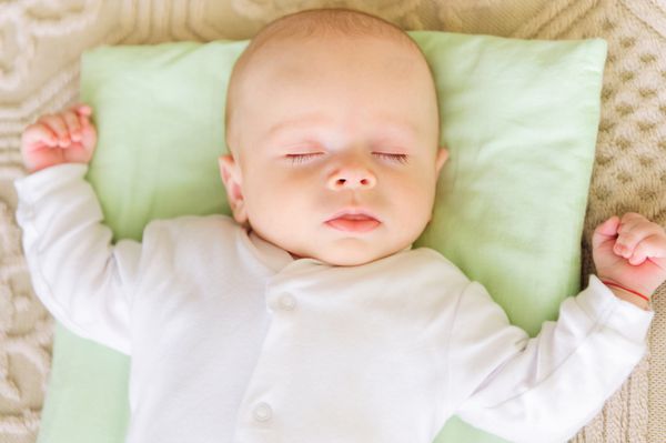 نوزاد ناز در تخت خواب روی بالش
