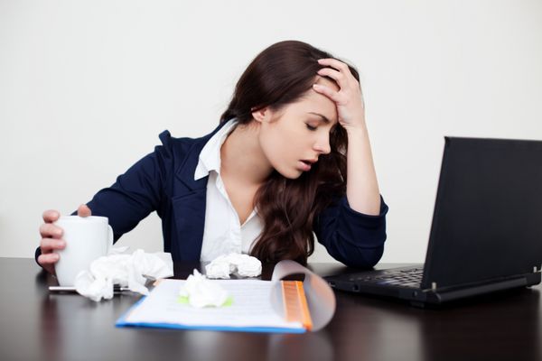 زن بیمار در محل کار با سردرد