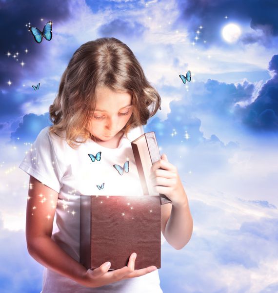 دختر خوشحالی که جعبه ای با پروانه های آبی باز می کند