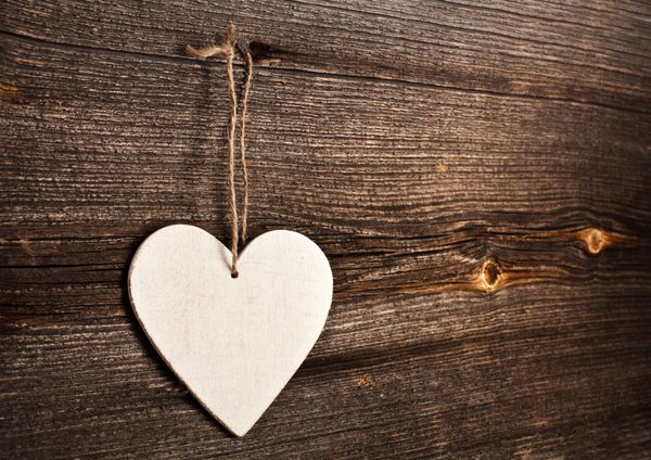 قلب عشق آویزان بر پس زمینه بافت چوبی مفهوم کارت روز