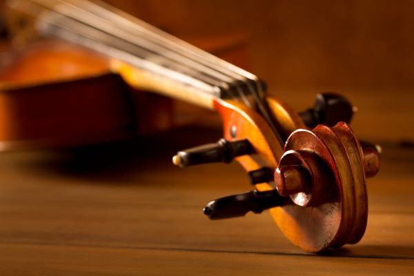 ویولن وینتاژ موسیقی کلاسیک در زمینه چوبی طلایی