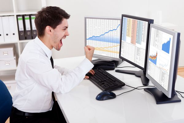 نمای بالای صفحه نمایش رایانه یک کارگزار سهام که در یک بازار صعودی معامله می‌کند و نمودارهای صعودی را نشان می‌دهد
