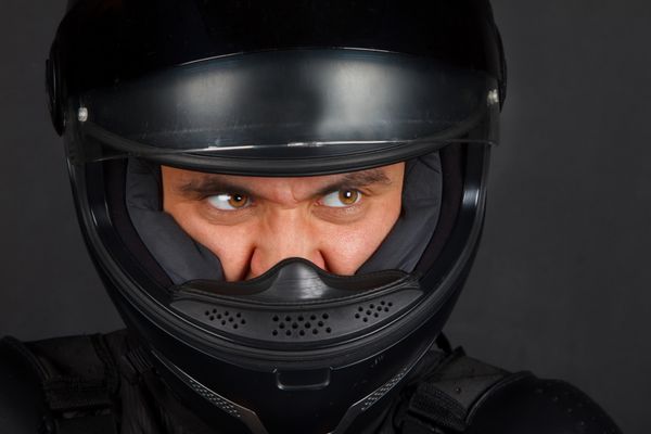 تصویر مردی با کلاه ایمنی موتورسیکلت با چشمان شیطانی