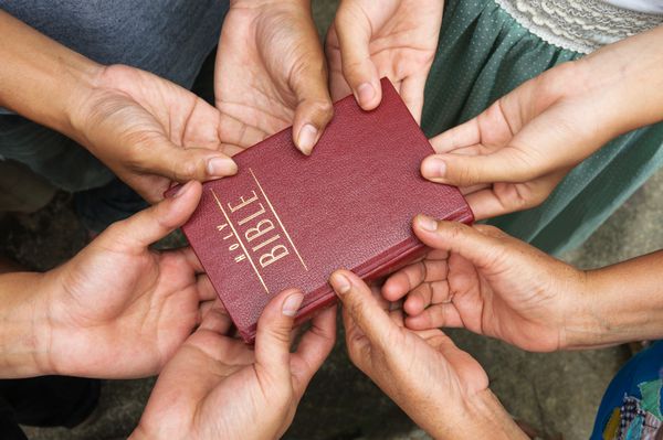 گروهی از مردم که کتاب مقدس را در دست دارند و دعا می کنند