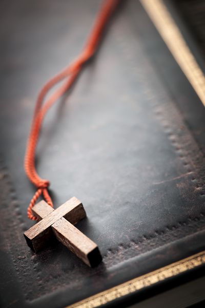 نمای نزدیک گردن صلیب مسیحی ساده چوبی روی کتاب مقدس با کپی sp