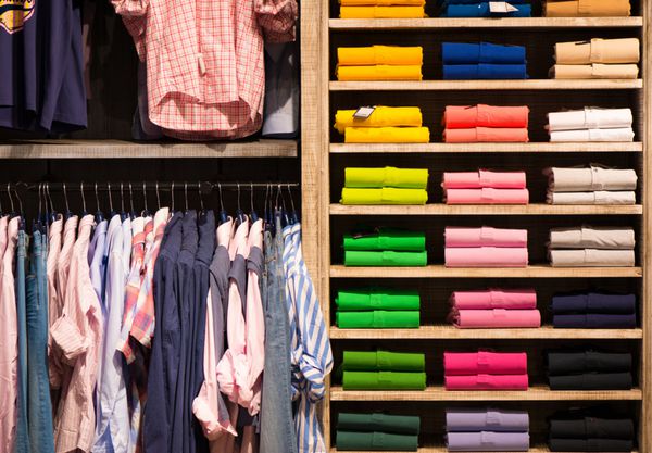 پیراهن های رنگی متنوع در قفسه فروشگاه