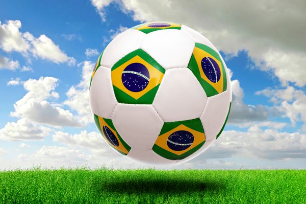 توپ فوتبال با پرچم برزیل در زمین سبز