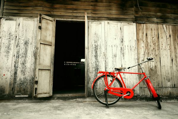 دوچرخه قرمز سبک قدیمی و در چوبی