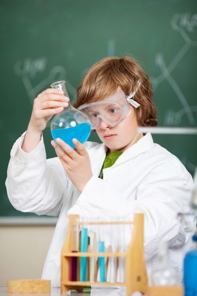 دانشجوی جوان در حال بررسی فرمول مایع داخل آزمایشگاه