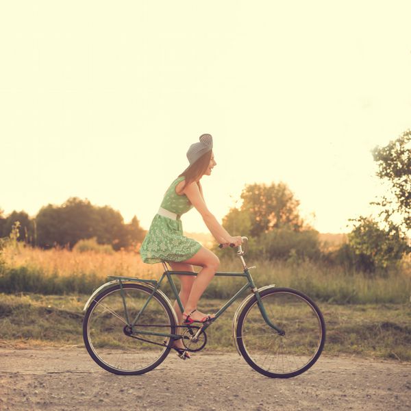 دختر زیبا سوار بر دوچرخه قدیمی