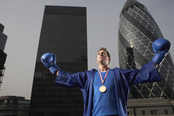 بوکسور مرد با مدال طلا در مقابل آسمان خراش های مرکز شهر در لندن