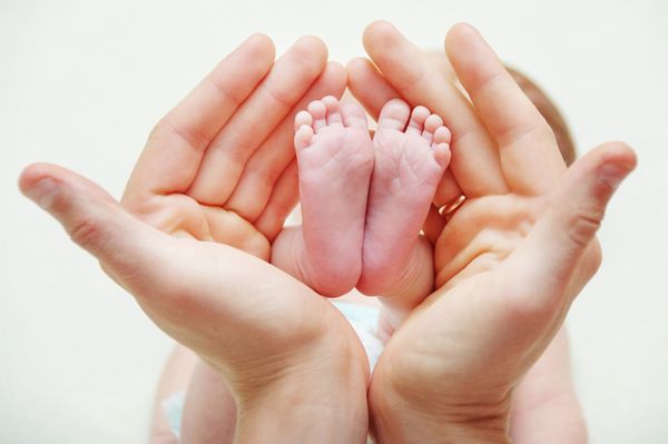 پای نوزاد تازه متولد شده در دستان مادر