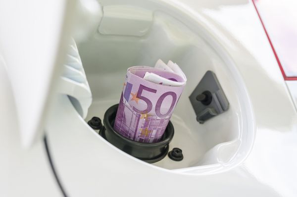 پول یورو در دهانه باک بنزین خودرو که نشان دهنده گاز یا سوخت گران قیمت است